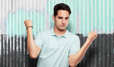 Genç yakışıklı latin adam güçlü işareti