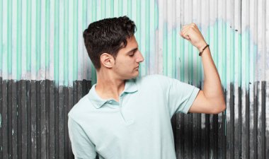 Genç yakışıklı latin adam güçlü işareti