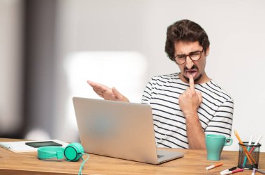 Genç sakallı adam grafik tasarımcı. Kusmuk işareti.