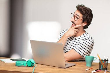 Genç sakallı adam grafik tasarımcı. Hayret ya da şok ifade.