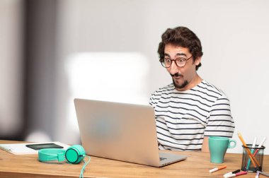 Genç sakallı adam grafik tasarımcı. Hayret ya da şok ifade.