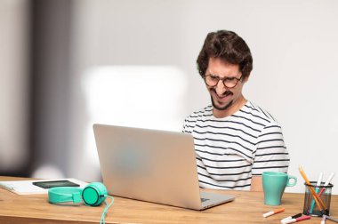 Genç sakallı adam grafik tasarımcı. Hayret ya da şok ifade.