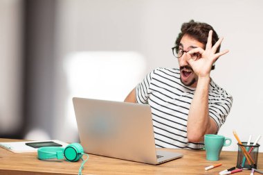 Genç sakallı adam grafik tasarımcı. Kapı dürbünü işareti.