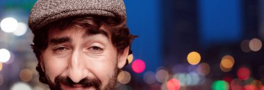 Genç deli adam kesme baş ifade izole sakallı. Bir bere takıyor. 