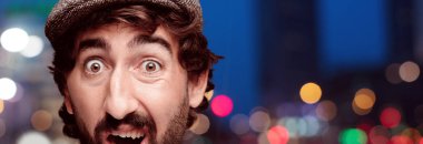 Genç deli adam kesme baş ifade izole sakallı. Bir bere takıyor. Korkmuş kavramı.