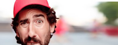 Genç deli adam izole kesme kafa ifadesiyle sakallı. Teslimat kurye rolü. Üzgün kavramı.