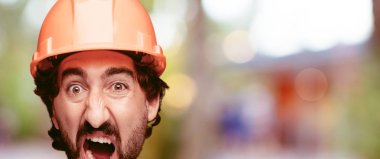 Genç deli adam kesme baş ifade izole sakallı. İnşa işçisi rolü. Kızgın ifade.