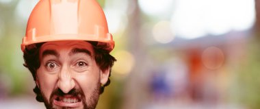 Genç deli adam kesme baş ifade izole sakallı. İnşa işçisi rolü. Kızgın ifade.