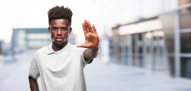 Genç serin siyah adam işareti. tek renkli bir arka plana dayanır kişi kesip