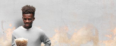 Genç adam patlamış mısır ile siyah. Sinema kavramı.