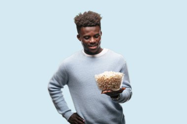 Genç adam patlamış mısır ile siyah. Sinema kavramı.