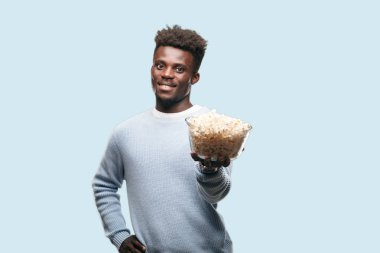 Genç adam patlamış mısır ile siyah. Sinema kavramı.