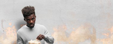 Genç adam patlamış mısır ile siyah. Sinema kavramı.