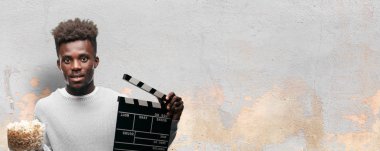 Genç adam patlamış mısır ile siyah. Sinema kavramı.