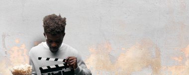 Genç adam patlamış mısır ile siyah. Sinema kavramı.