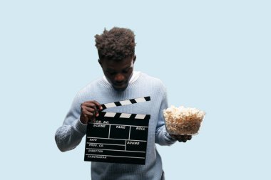 Genç adam patlamış mısır ile siyah. Sinema kavramı.