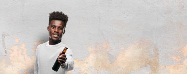 bir bira olan genç siyah adam