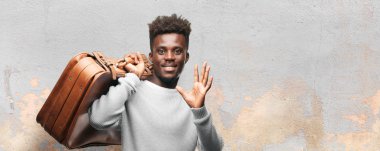 Genç adam bir deri çanta siyah. Seyahat veya turist kavramı.