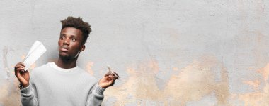 Genç siyah adam yatılı geçiş bileti ile ve bir uçak modeli. Seyahat kavramı.