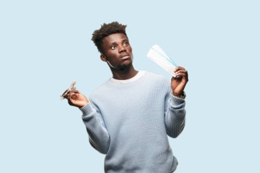 Genç siyah adam yatılı geçiş bileti ile ve bir uçak modeli. Seyahat kavramı.