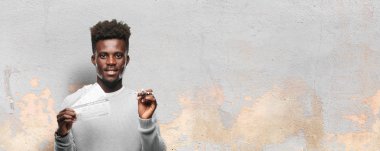 Genç siyah adam yatılı geçiş bileti ile ve bir uçak modeli. Seyahat kavramı.