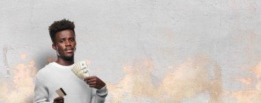 Genç adam bir kredi kartı ile siyah. Para kavramı.