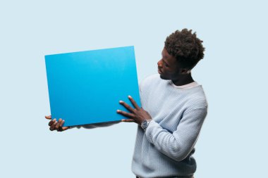 Senin konseptin yerleştirmek için boş bir afişini tutan genç siyah adam