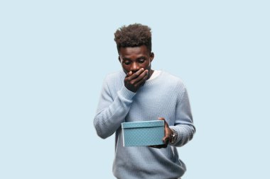 bir hediye kutusu tutan genç siyah adam