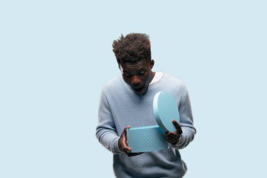 bir hediye kutusu tutan genç siyah adam