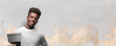 bir hediye kutusu tutan genç siyah adam