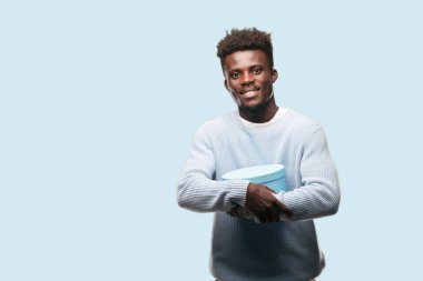 bir hediye kutusu tutan genç siyah adam