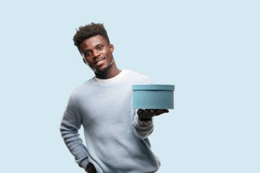 bir hediye kutusu tutan genç siyah adam