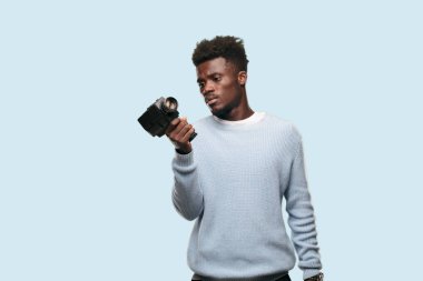 Genç siyah adam bir super 8 vintage sinema kamera ile kayıt