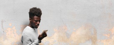 Genç siyah adam akıllı bir cep telefonu kullanarak