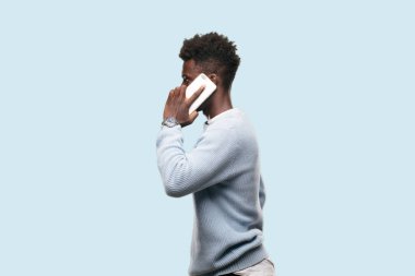 Genç siyah adam akıllı bir cep telefonu kullanarak