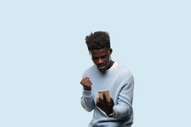 Genç siyah adam akıllı bir cep telefonu kullanarak