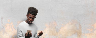 Genç siyah adam akıllı bir cep telefonu kullanarak