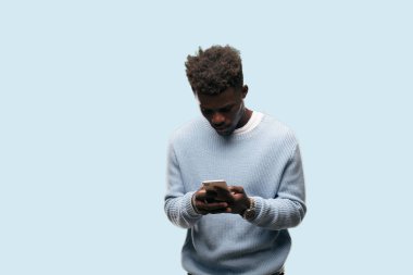 Genç siyah adam akıllı bir cep telefonu kullanarak