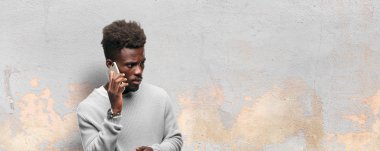 Genç siyah adam akıllı bir cep telefonu kullanarak