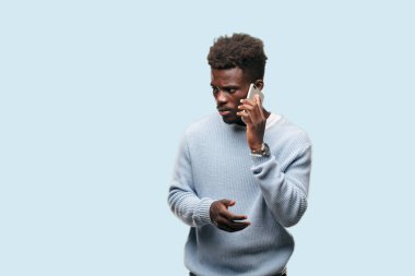 Genç siyah adam akıllı bir cep telefonu kullanarak