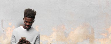 Genç siyah adam akıllı bir cep telefonu kullanarak