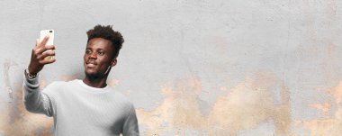 Genç siyah adam akıllı bir cep telefonu kullanarak