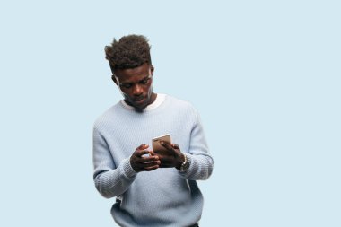 Genç siyah adam akıllı bir cep telefonu kullanarak