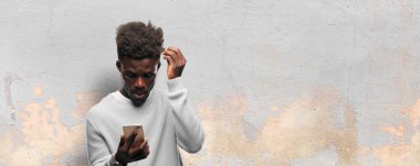 Genç siyah adam akıllı bir cep telefonu kullanarak