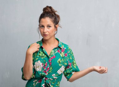 Senin konseptin yerleştirmek için çimento duvar arka plan boşluk ile poz genç güzel kadın