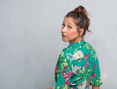 Senin konseptin yerleştirmek için çimento duvar arka plan boşluk ile poz genç güzel kadın