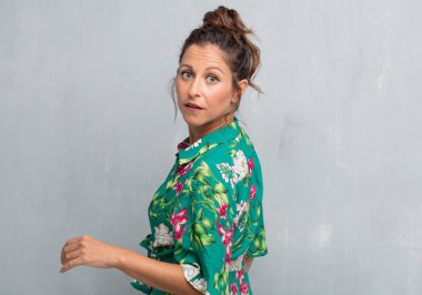 Senin konseptin yerleştirmek için çimento duvar arka plan boşluk ile poz genç güzel kadın