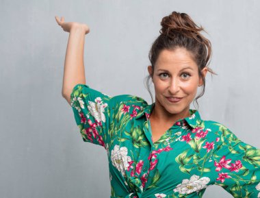 Senin konseptin yerleştirmek için çimento duvar arka plan boşluk ile poz genç güzel kadın