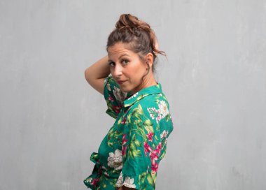 Senin konseptin yerleştirmek için çimento duvar arka plan boşluk ile poz genç güzel kadın