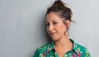 Senin konseptin yerleştirmek için çimento duvar arka plan boşluk ile poz genç güzel kadın